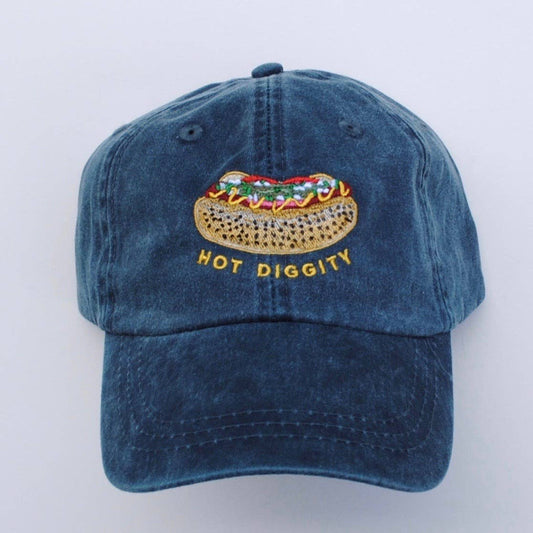 Faded blue baseball hat with embroidery of hot dog with poppy seed bun and chicago-style toppings. Yellow embroidered text underneath hot dog says "Hot Diggity."