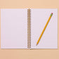 Notebook open to show lined pages. Spiral bound with a pencil.