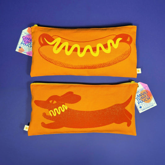 Two orange pouches with hot dog design on a purple background
