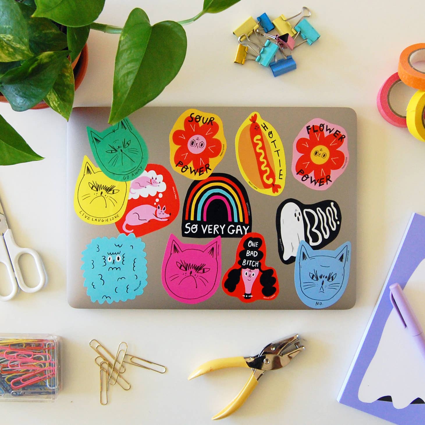 Laptop with colorful stickers on a desk with office supplies