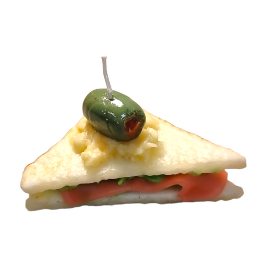 Wax candle shaped like a half sandwich, with olive garnish on top.