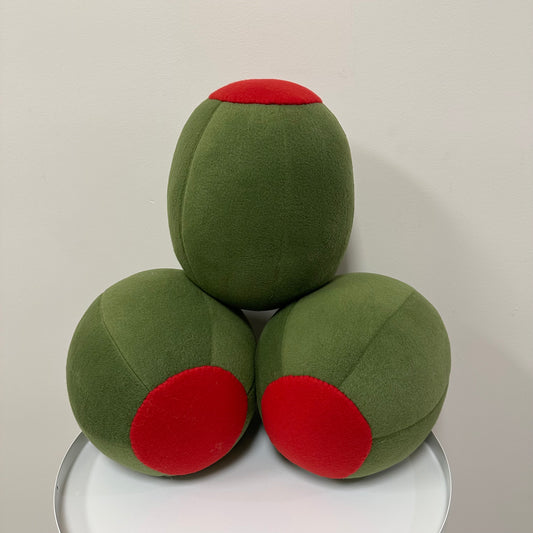 Three green olive pillows stacked on top of eachtoher.