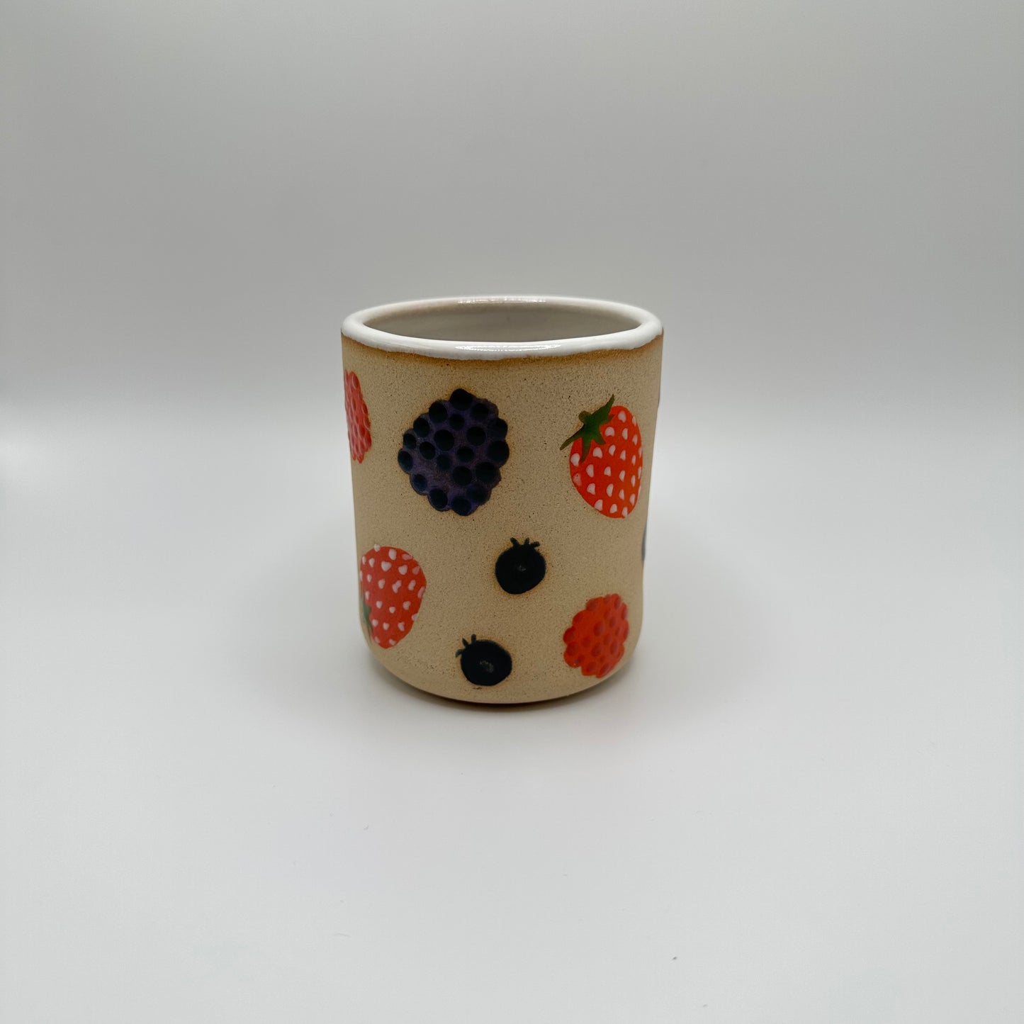 Ceramic tumbler adorned with hand painted mixed berries.