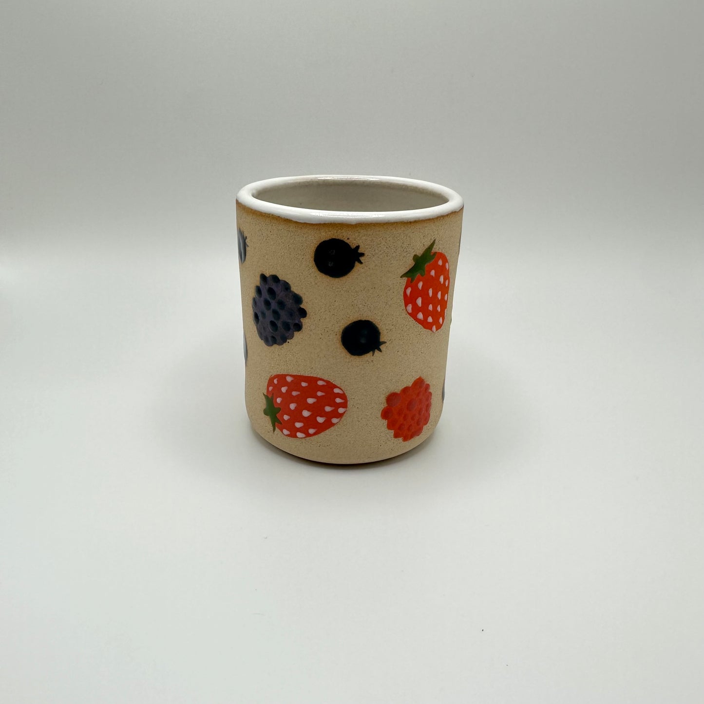 Ceramic tumbler adorned with hand painted mixed berries.