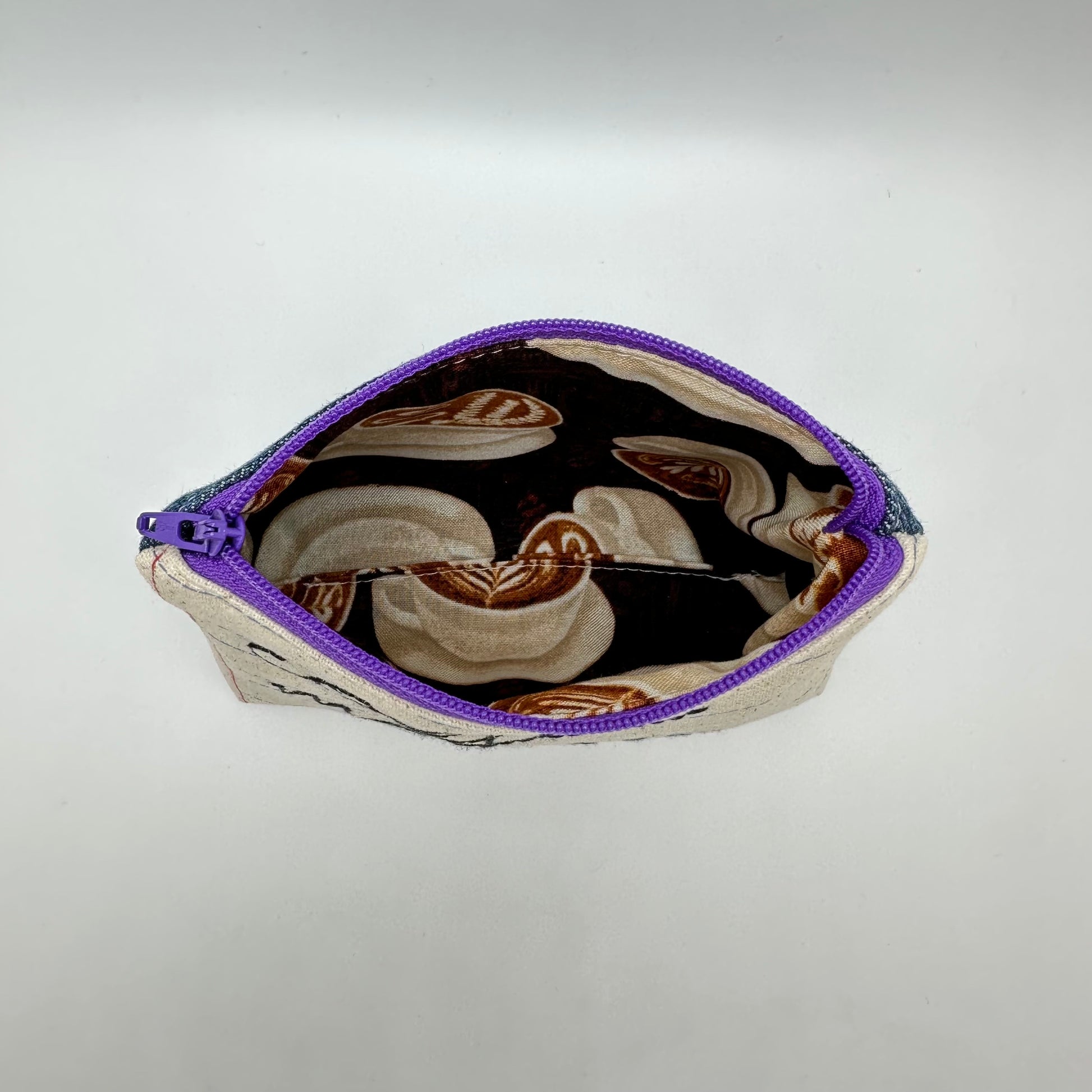 Inside of pouch showing fabric of a. coffee latte pattern.