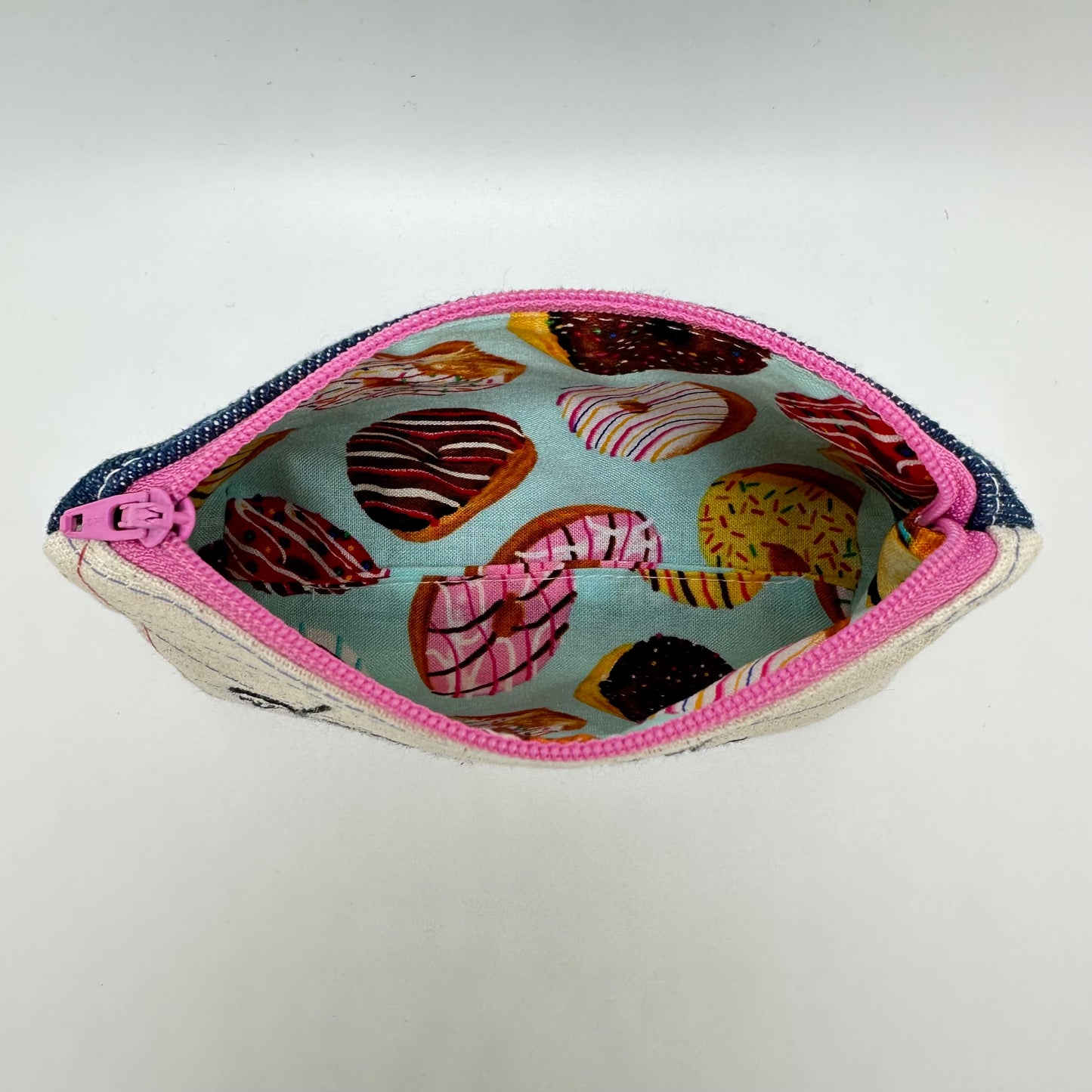 Inside of pouch showing fabric that has an assorted donut pattern.