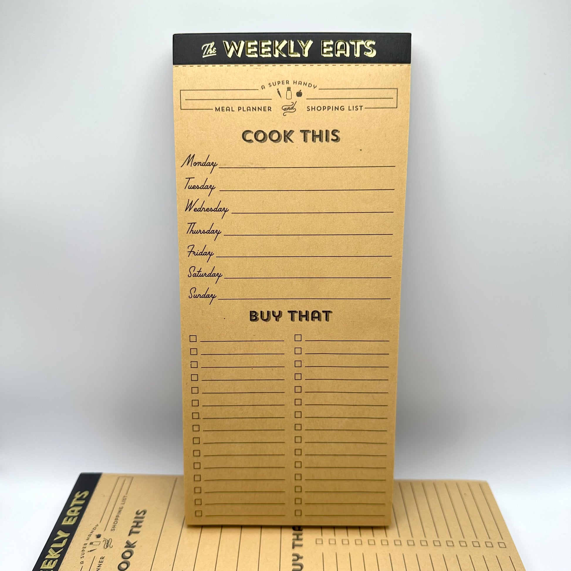 Weekly meal planner notepad. Top portion of the pad has days of the week, bottom portion has a checklist for grocery items to buy.