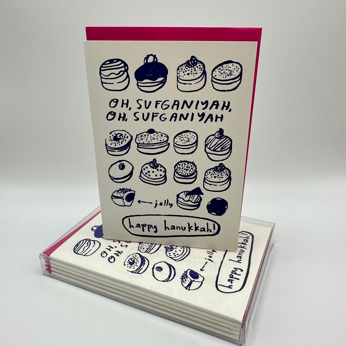 Hanukkah card filled with assorted jelly donuts. Card reads" Oh Sufganiyah, oh Sufganiyah. Single card sitting on top of a boxed set of the same cards,