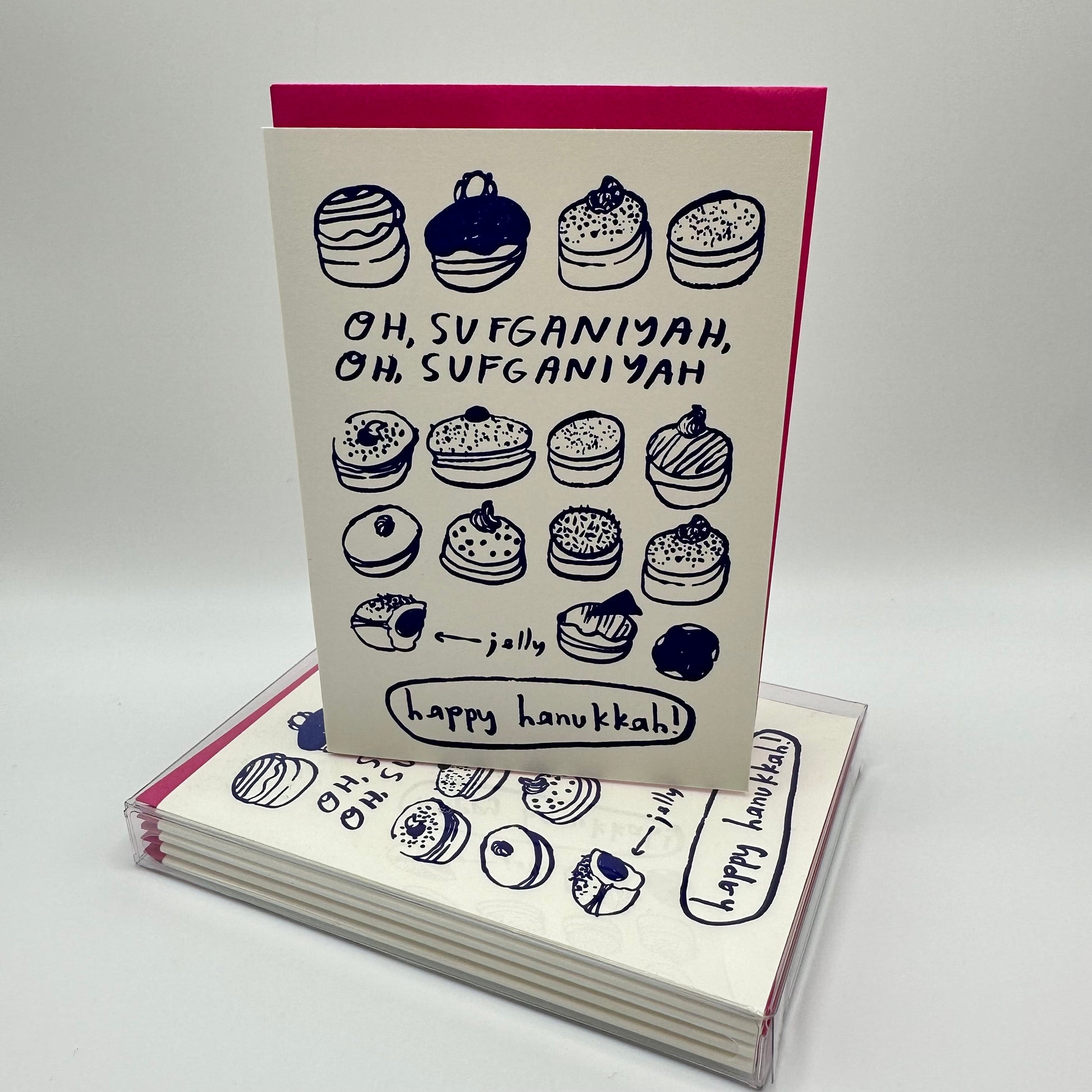 Hanukkah card filled with assorted jelly donuts. Card reads" Oh Sufganiyah, oh Sufganiyah. Single card sitting on top of a boxed set of the same cards,