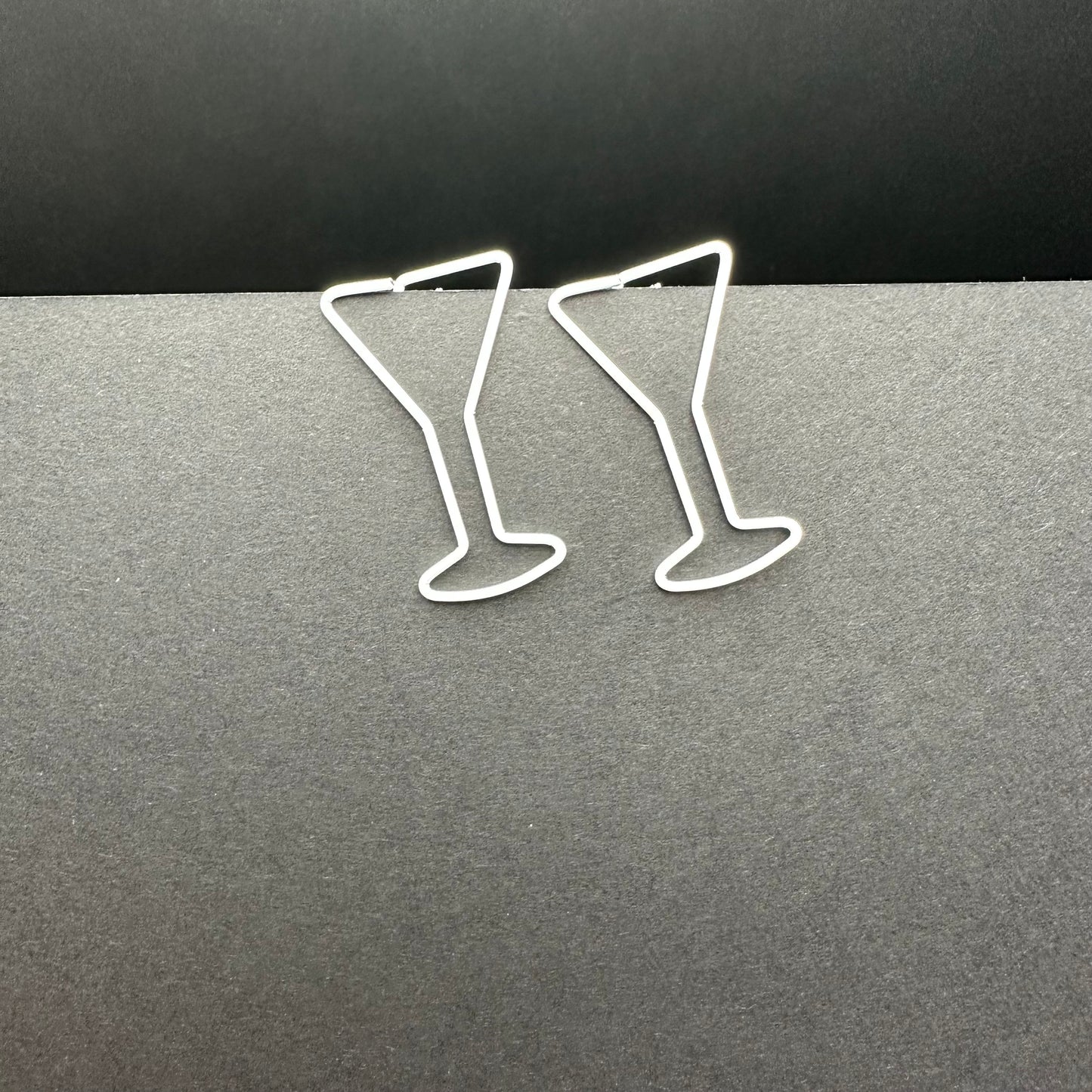Two martini paperclips clipped on piece of paper.