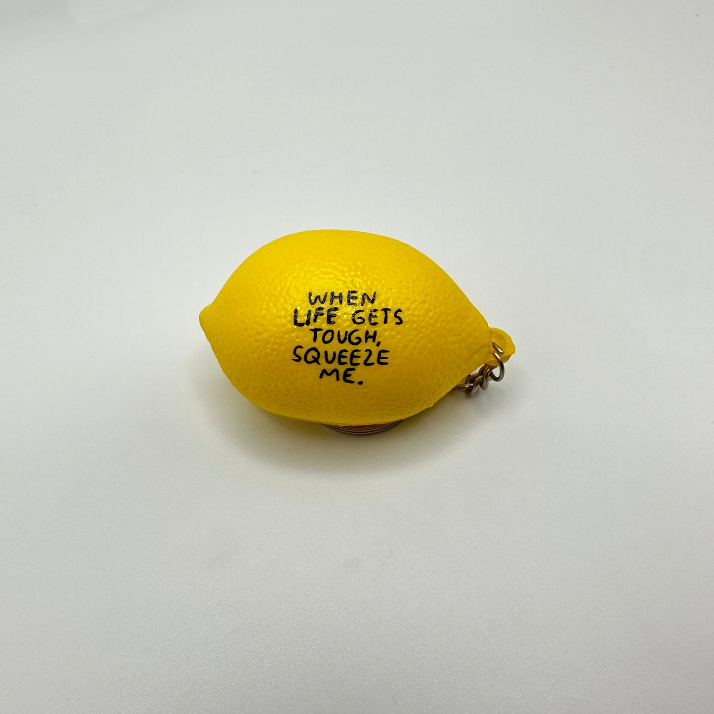 Lemon stress ball keychain that reads: When life gets tough, squeeze me.