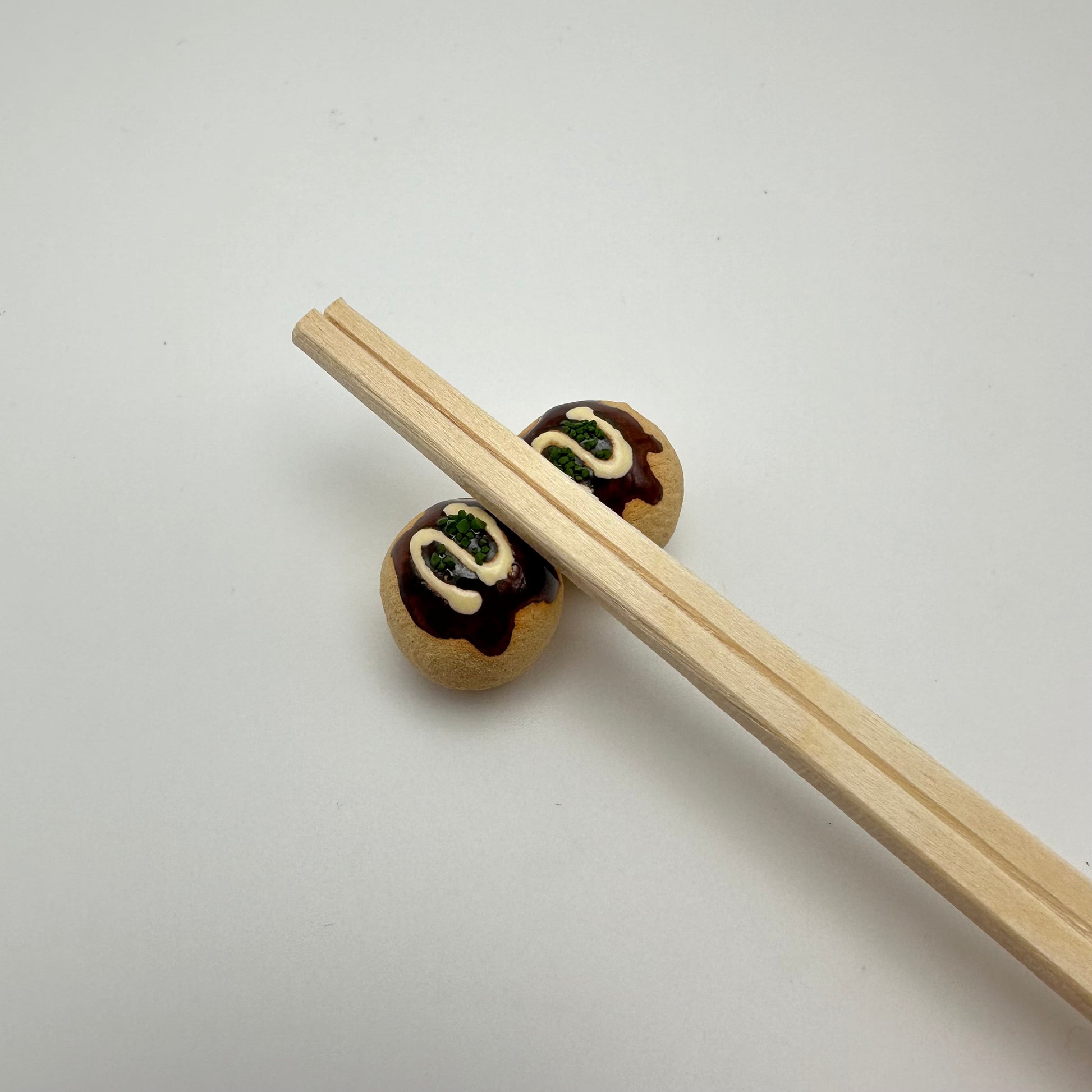 Takoyaki chopstick holders with chopsticks on top.