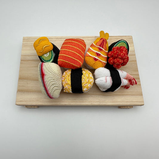 Mini fabric assorted sushi on a wood board.
