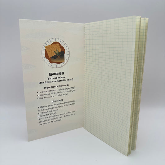Inside of notebook reveals a recipe for using Mackerel. Notebook has grid pages.