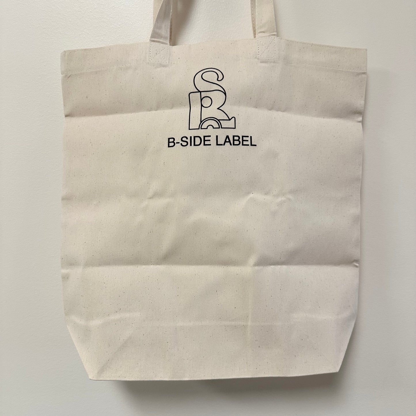 Back side of tote bag that has the logo for B-Side Label.