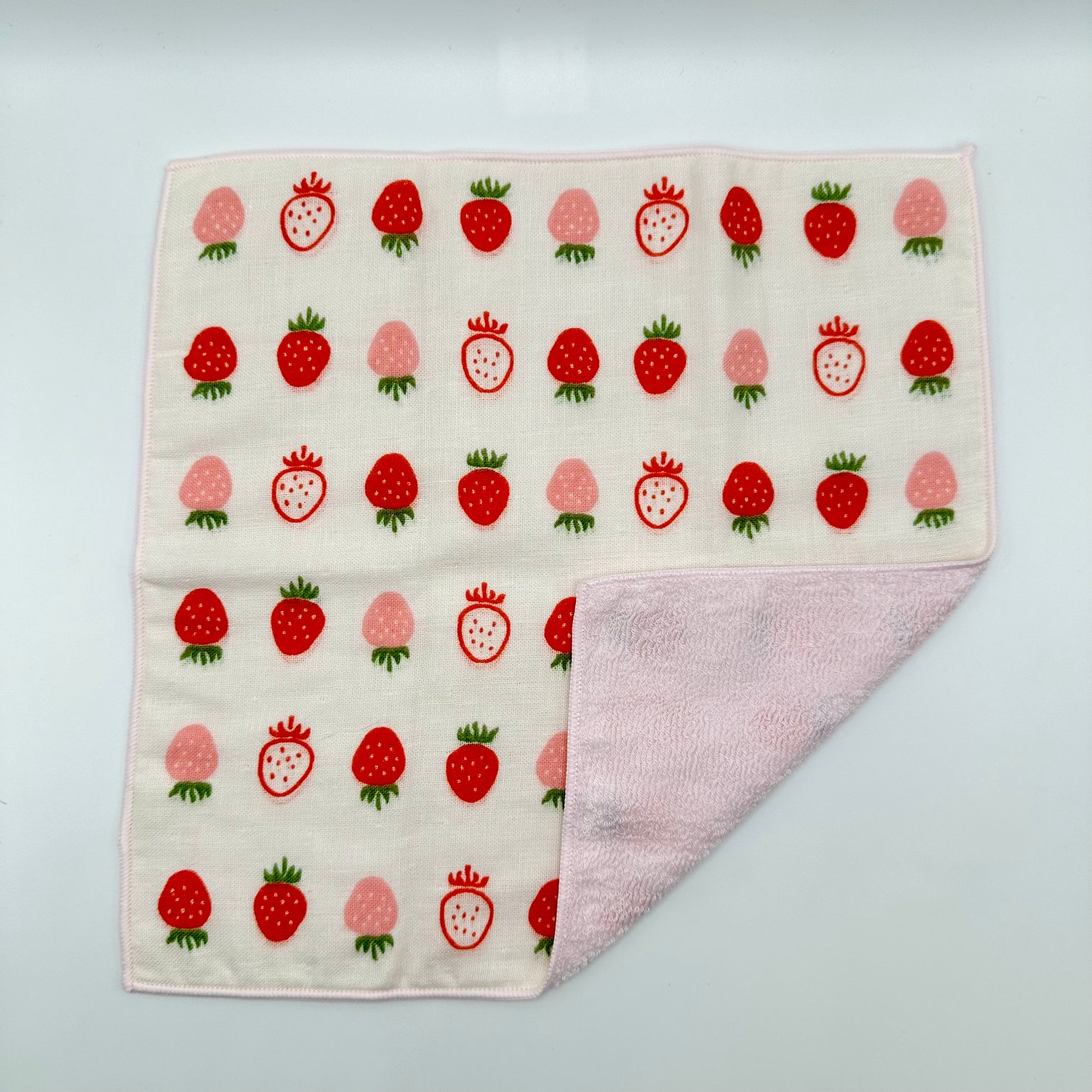 Hand towel with assorted strawberries. 