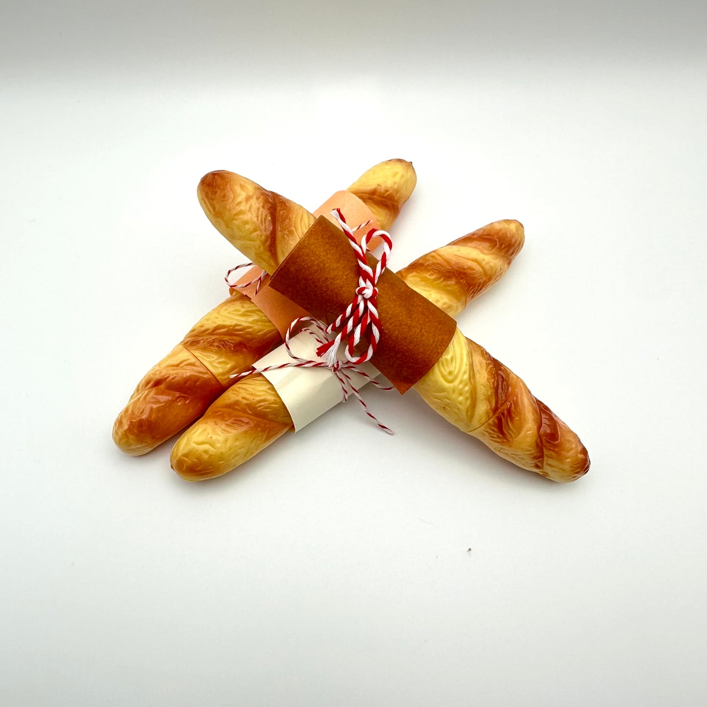 Three baguette pens wrappedin paper and twine