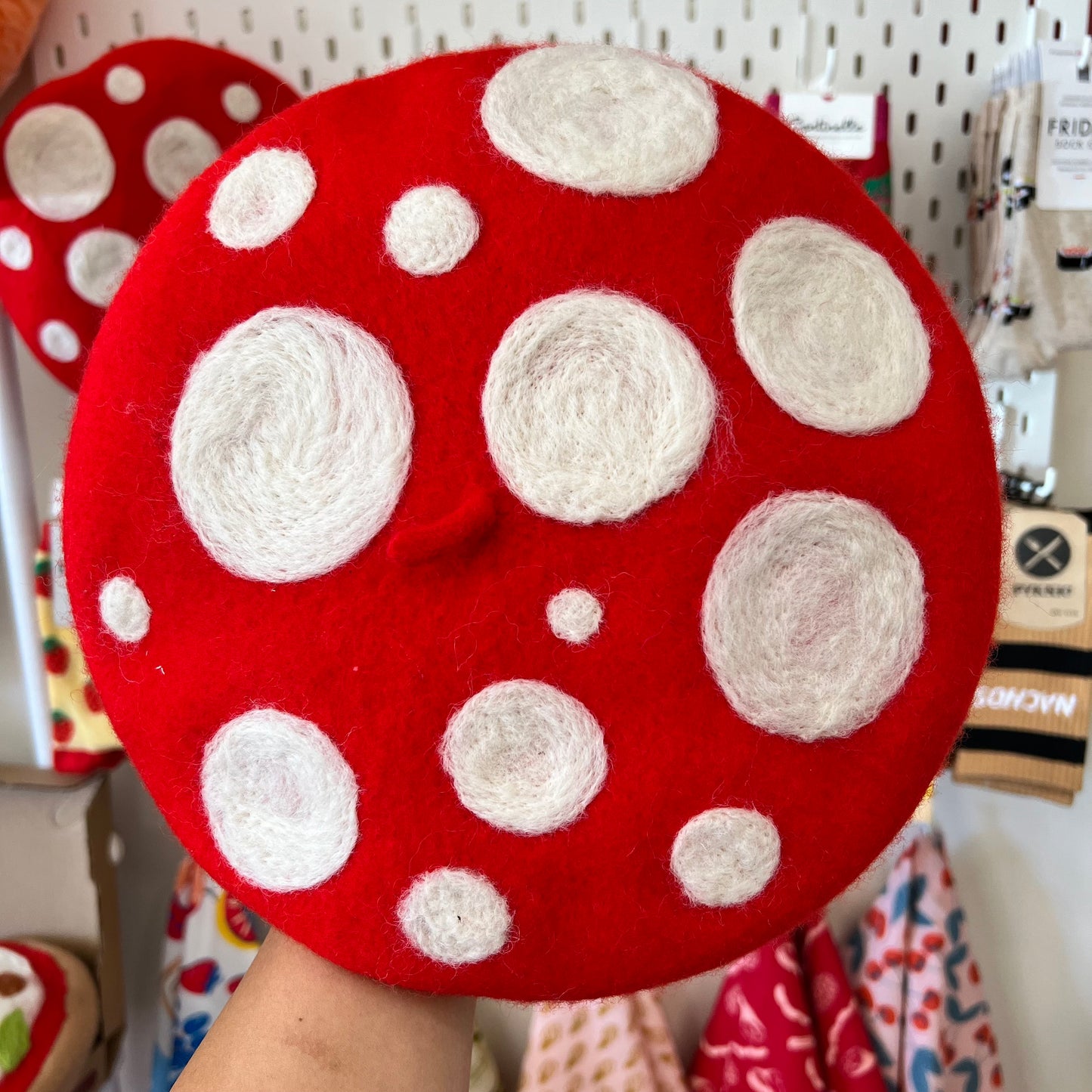 Wool-felted toadstool mushroom design on a red beret.