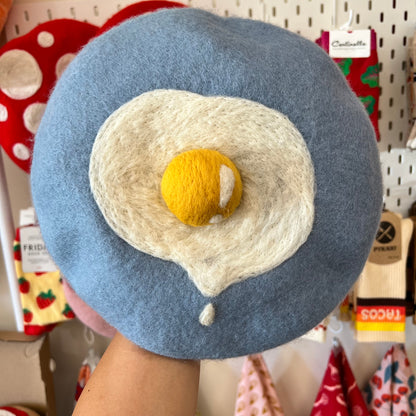 Blue beret with single drippy egg detailing.