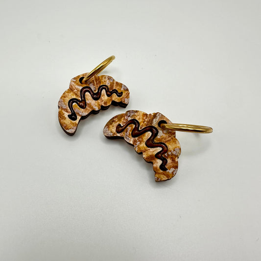 Chocolate croissant earrings with gold hoops. 