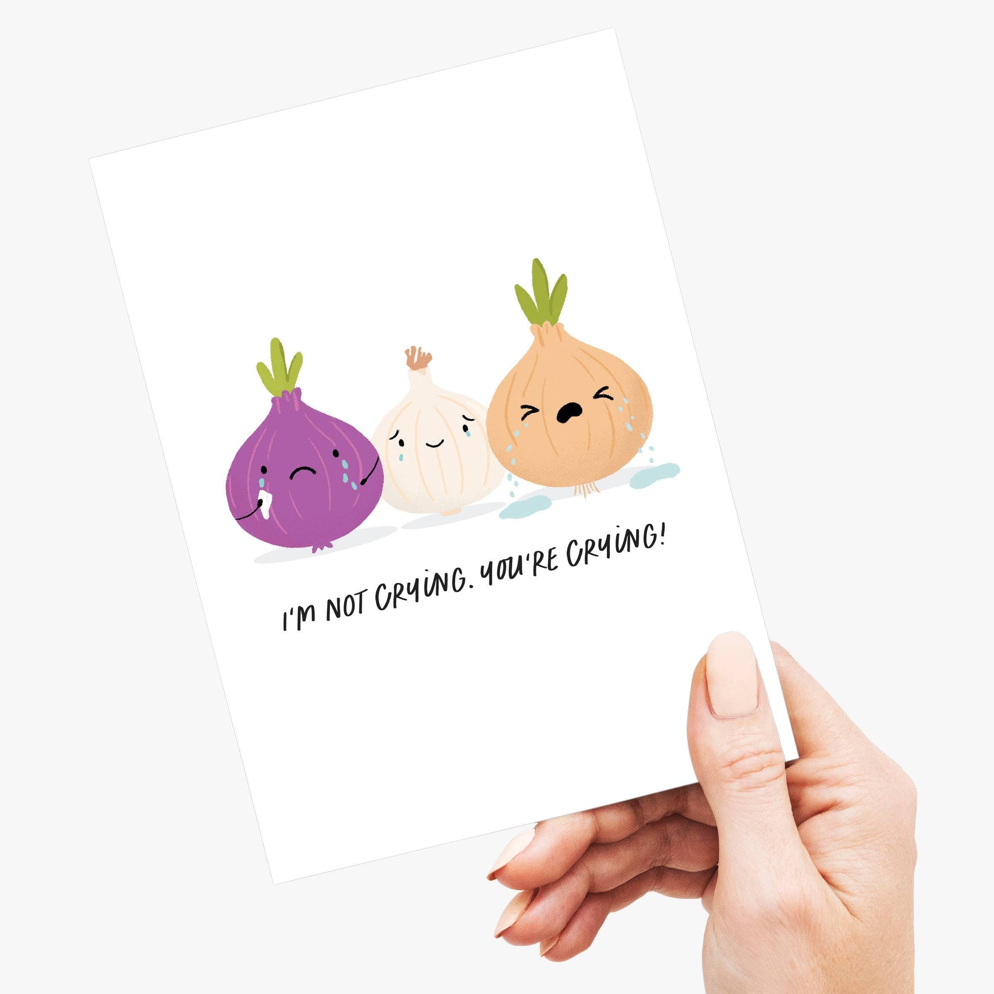 Hand holding a white pillow with cartoon onions on a white background