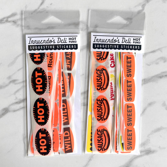 Two packages of Innuendo's Deli suggestive stickers on a marble background