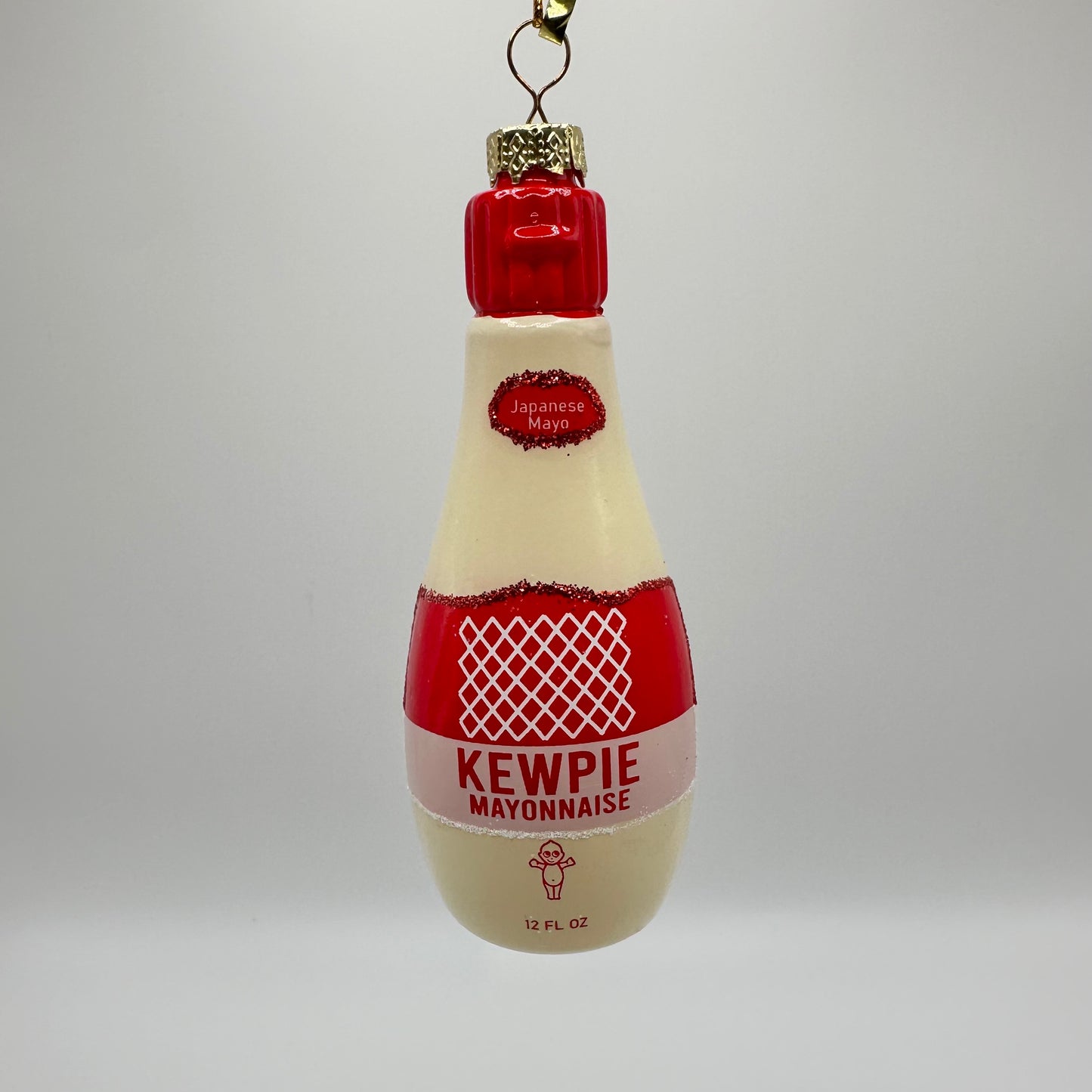 Glass ornament that looks like a Japanese Kewpie mayo bottle complete with red logo and kewpie doll image.