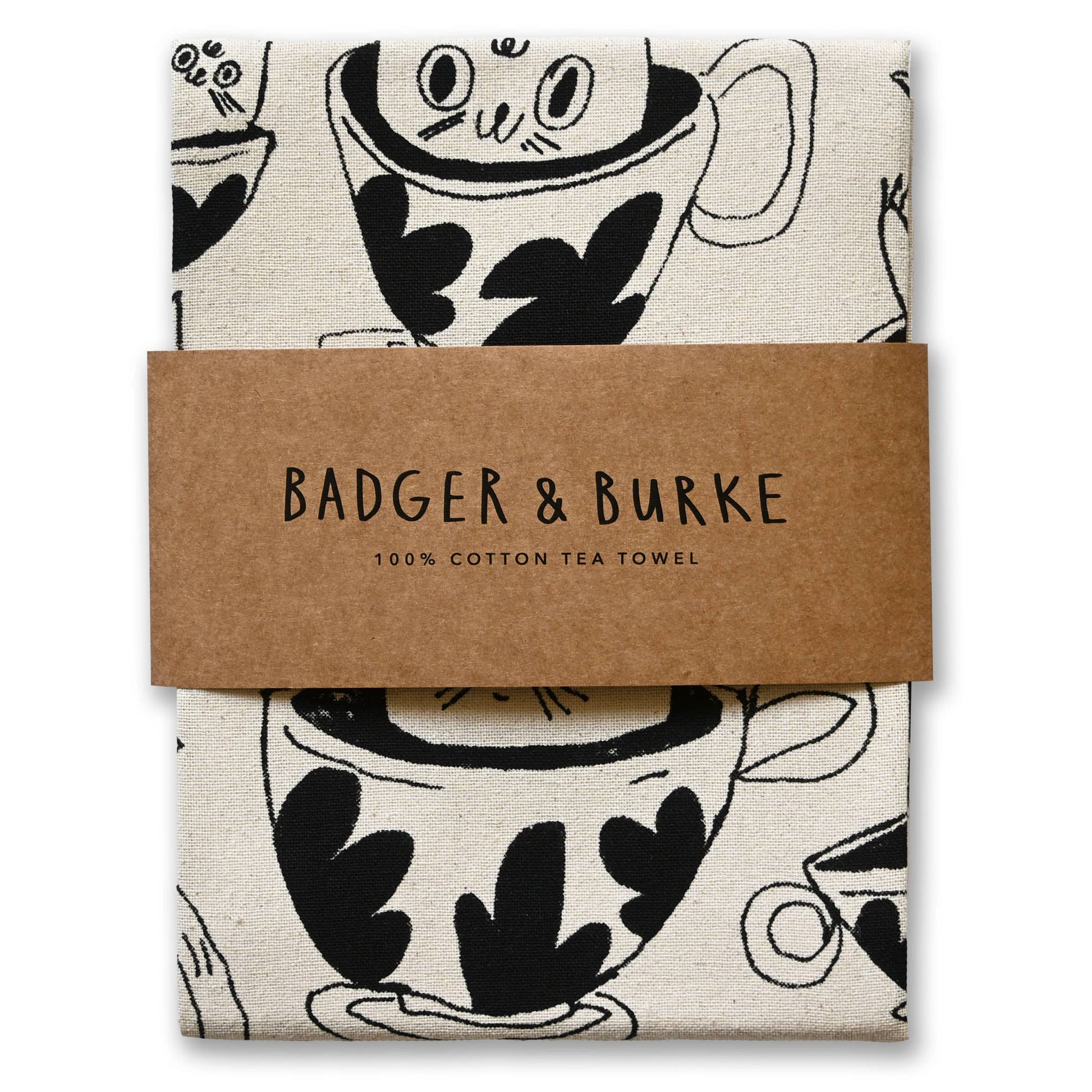 A folded cotton tea towel with a black and white coffee cup pattern, wrapped in a brown paper band that reads 'BADGER & BURKE 100% COTTON TEA TOWEL'.
