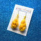 Lemon mesh bag earrings on card backing that reads "shop velanidi. handmade with fun" All on blue, glittery background 