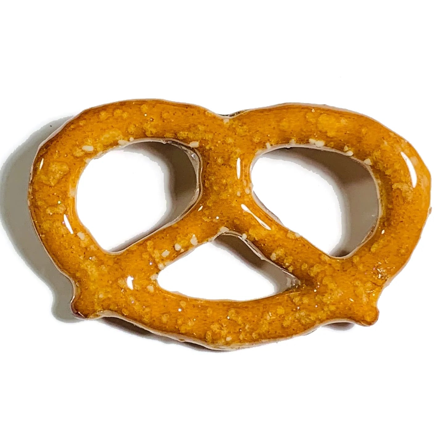 Large pretzel coated in glitter resin and turned into a brooch/pin