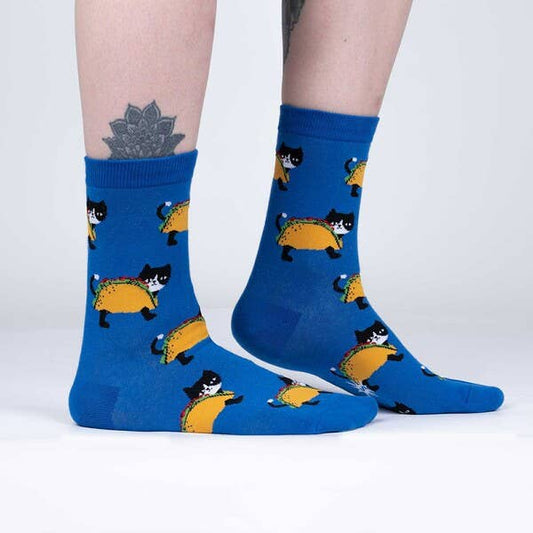 Model wearing blue socks that have taco cats on them.