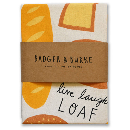 Cotton tea towel with orange and beige bread pattern and 'Badger & Burke' branding.