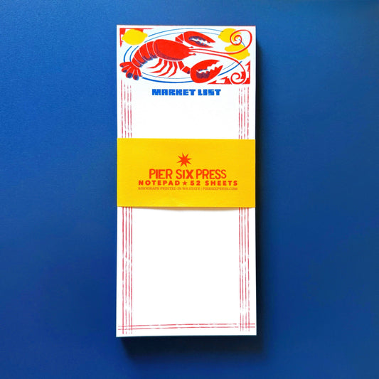 Notepad with lobster design and 'Pier Six Press' branding on a blue background