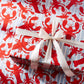 Gift wrapped in red lobster patterned paper with a white ribbon.