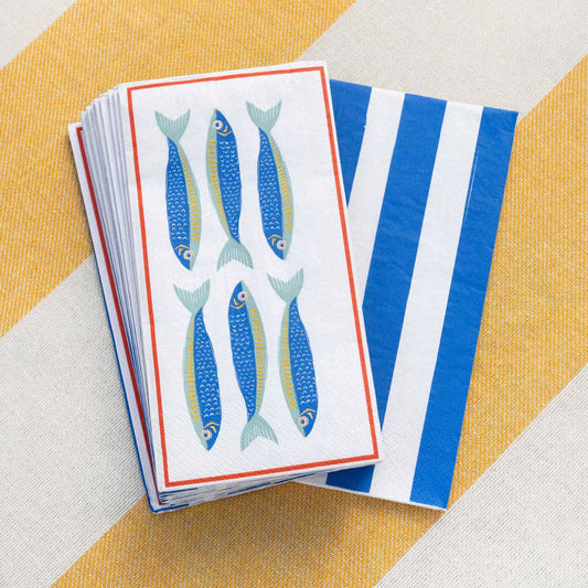 Stack of paper napkins with fish design on a striped yellow and white background