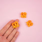 Hand holding pretzel magnet. 2 others are on a table with a pink backdrop.