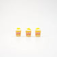 Three mini popcorn magnets standing in a row.