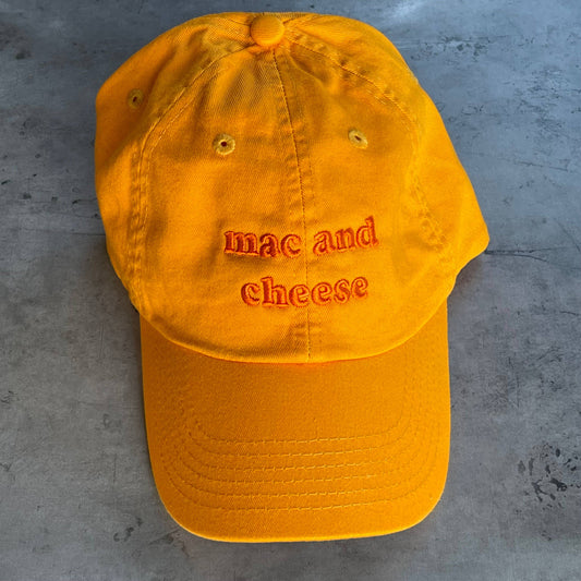 Orange hat with orange embroidery that reads: mac and cheese