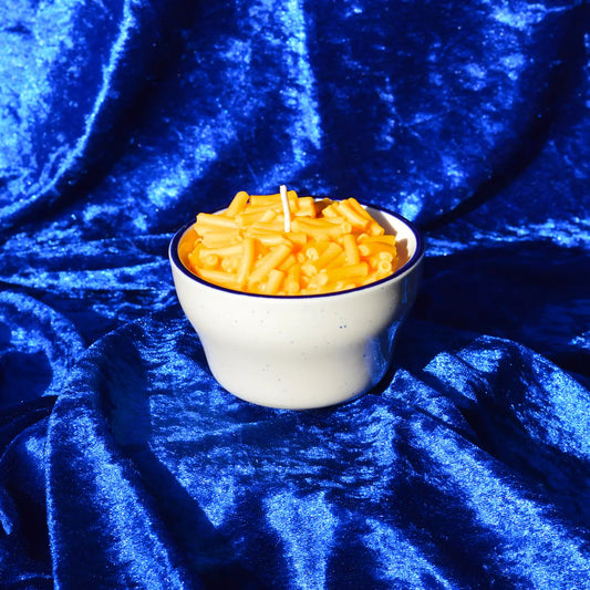Mac and Cheez candle in a porcelain bowl with crushed velvet blue backdrop.