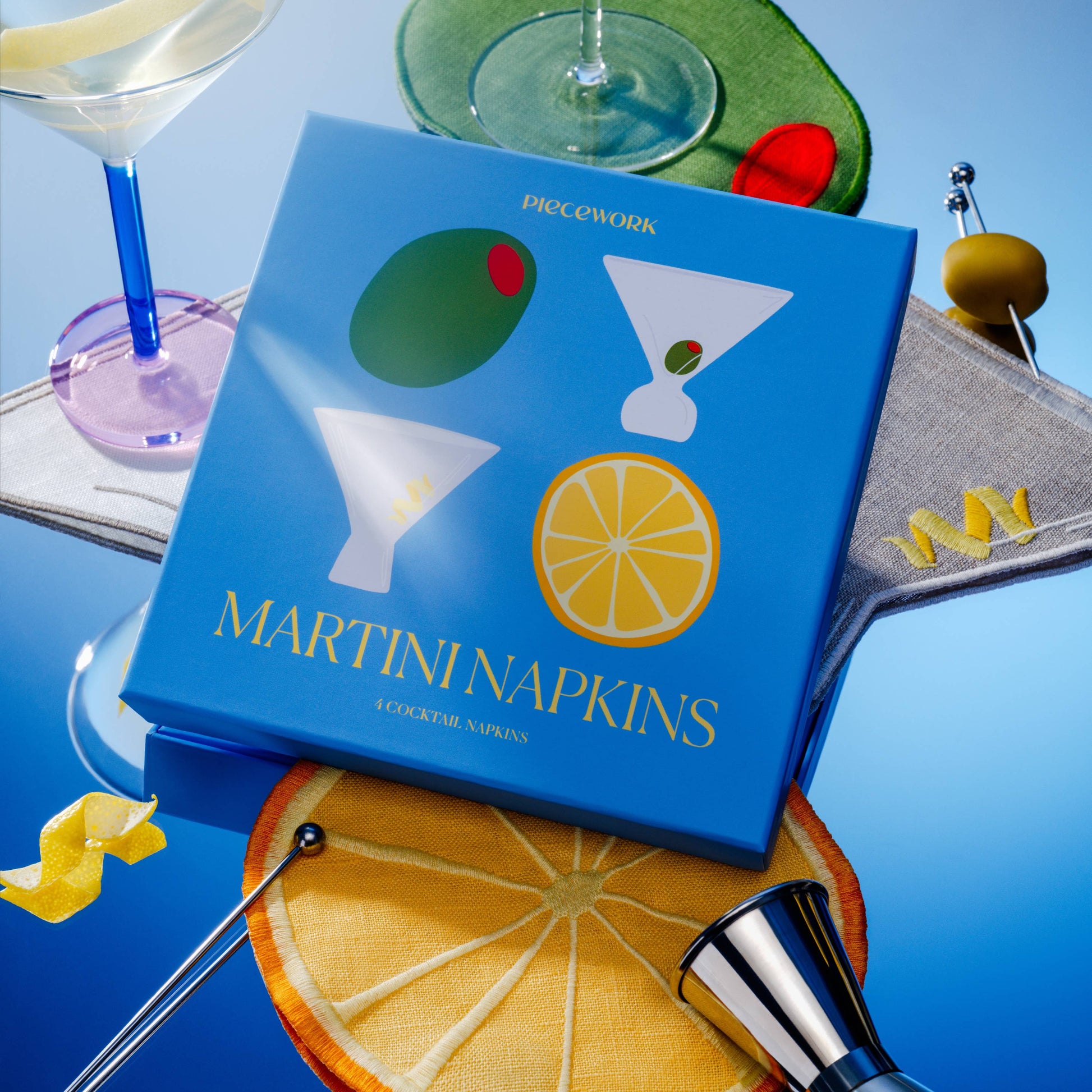 Blue box of Martini Napkins with cocktail-themed design on a blue background with bar accessories.