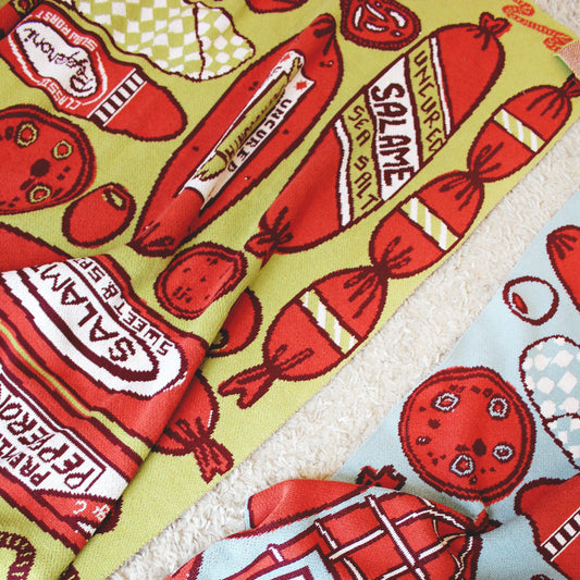 Meat Shop textile. Blanket has a print of salami, pancetta, pepperoni, etc.