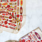 Two Meat Shop towels displaying the different color schemes. BOth towels have assorted meat, salami and cold cuts.