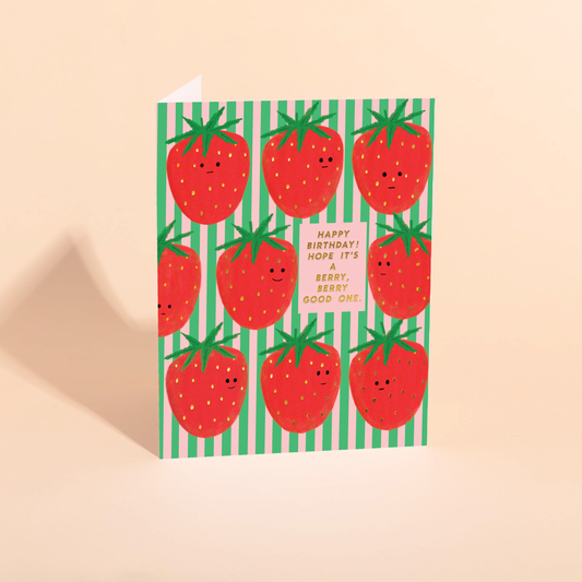 birthday card with a pink and green vertical stripe background with smiley faced big strawberries all over