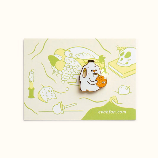 Lapel pin of a milk jug drinking an orange out of a straw. Card backing reflects decaying food.