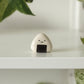 Photo of single mini onigiri-shaped bud vase sitting on a white shelf.