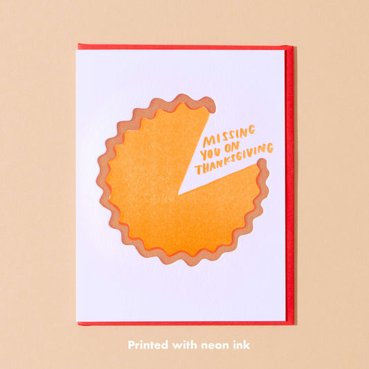 Thanksgiving greeting card with a pumpkin pie on it with a slice missing. In the gap, there's text that reads "Missing you on Thanksgiving" 