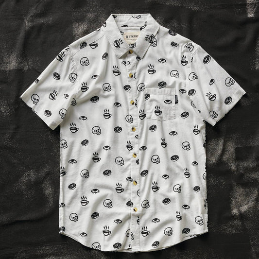 White button up shirt with tortoise buttons. Patterned with skulls, donuts, coffee and eyes. 