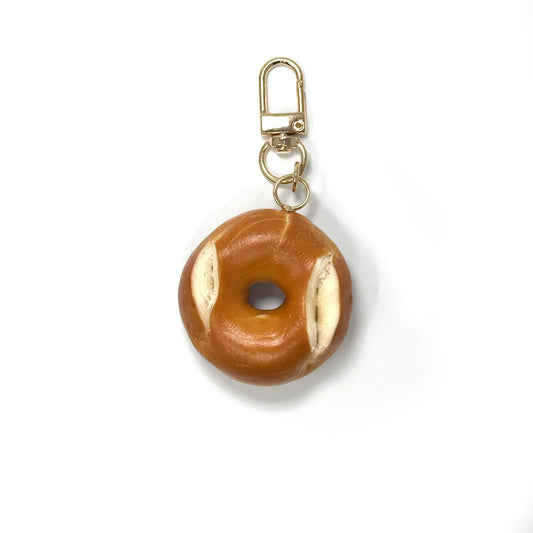 Mini keychain shaped like a realistic bagel (front view).