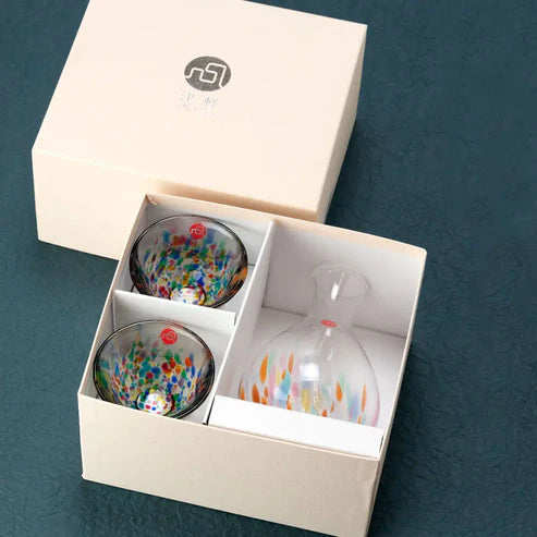 Set of colorful sake glass set in a box with a visible brand logo on a dark blue background.
