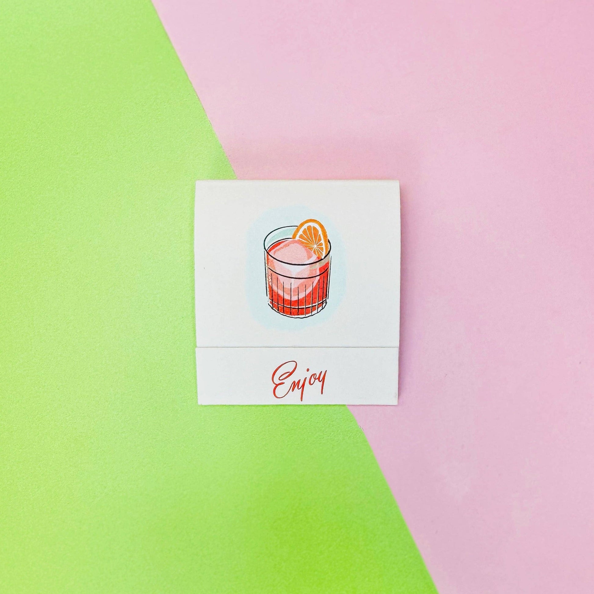 Exterior of front of Negroni matchbook -- designed with a negroni cocktail in center and on bottom flap it reads "Enjoy" 